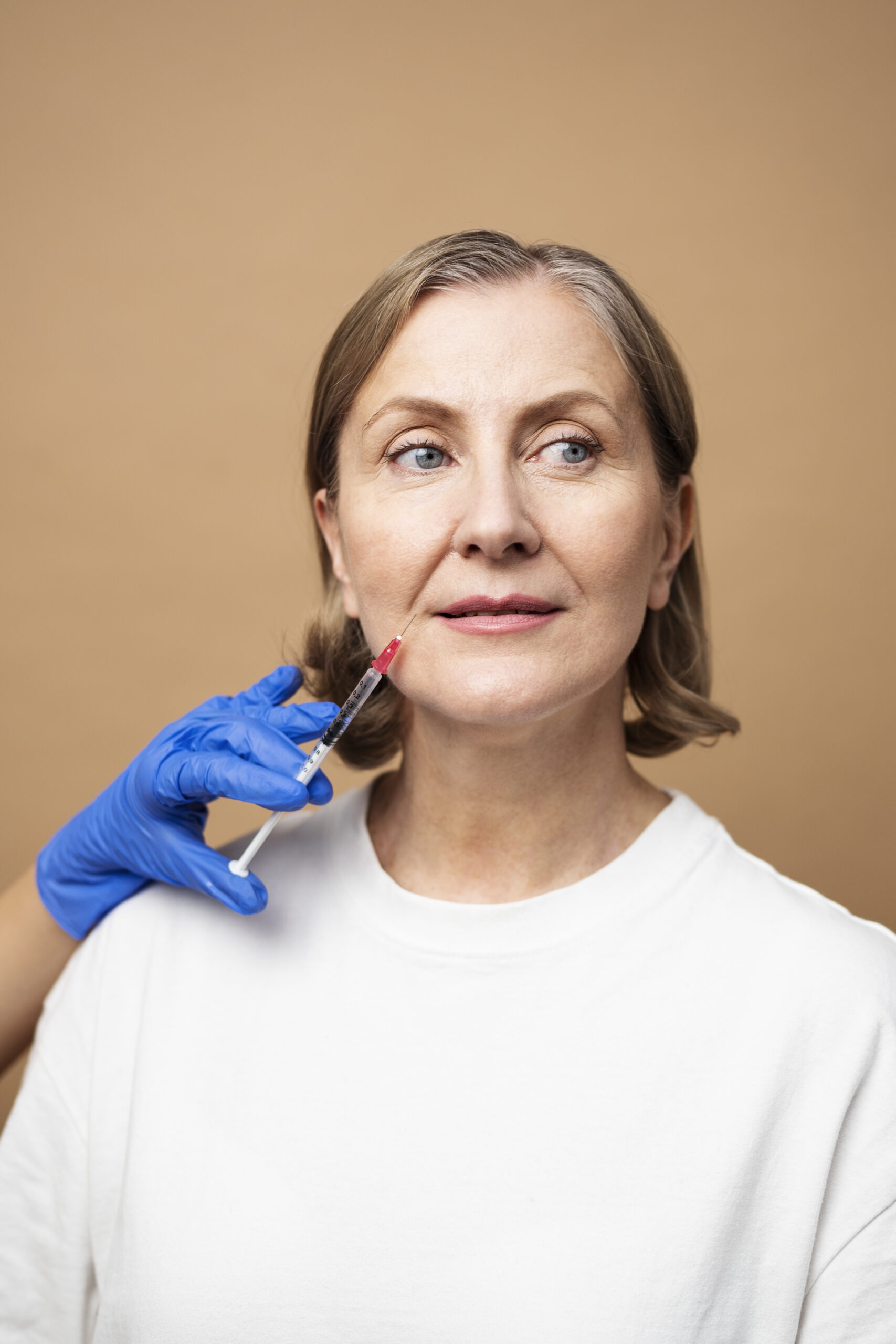 woman with a syringe shot about to get nasolabial folds treatment