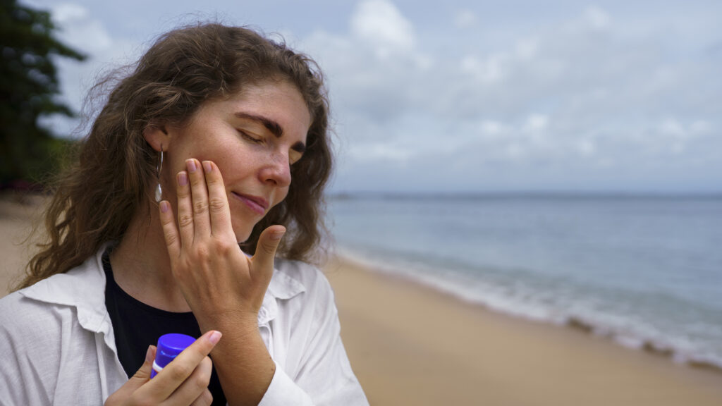 Woman in the beach touching her skin after skincare